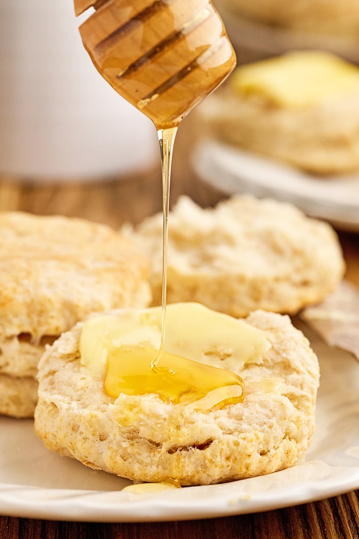 Open biscuit with butter and honey.