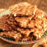 Pieces of Peanut Brittle on serving dish.