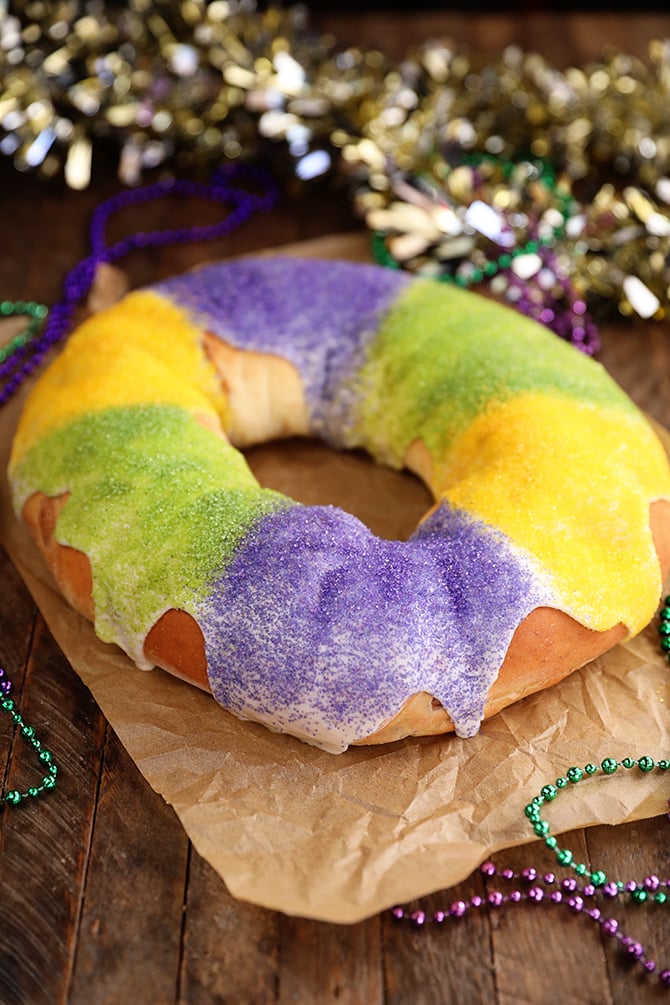 King Cake on brown paper with Mardi Gras decoration