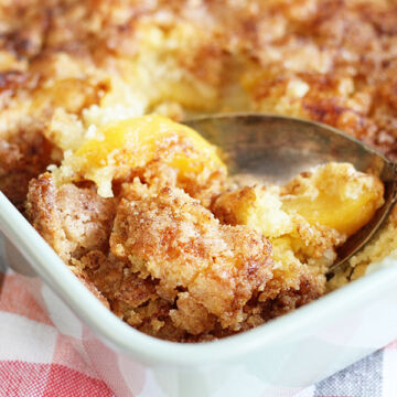 Peach Cobbler being scooped from baking dish