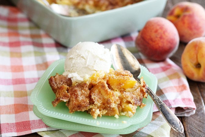 Peach Cobbler with fresh peaches around plate