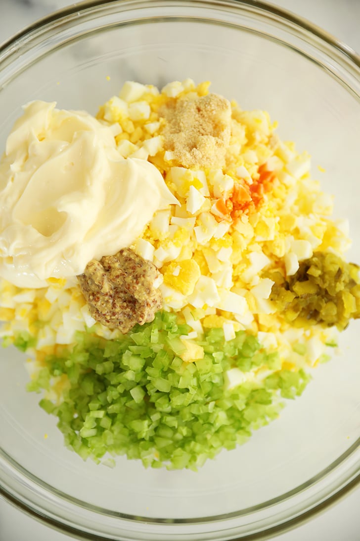 egg salad ingredients in a clear bowl.