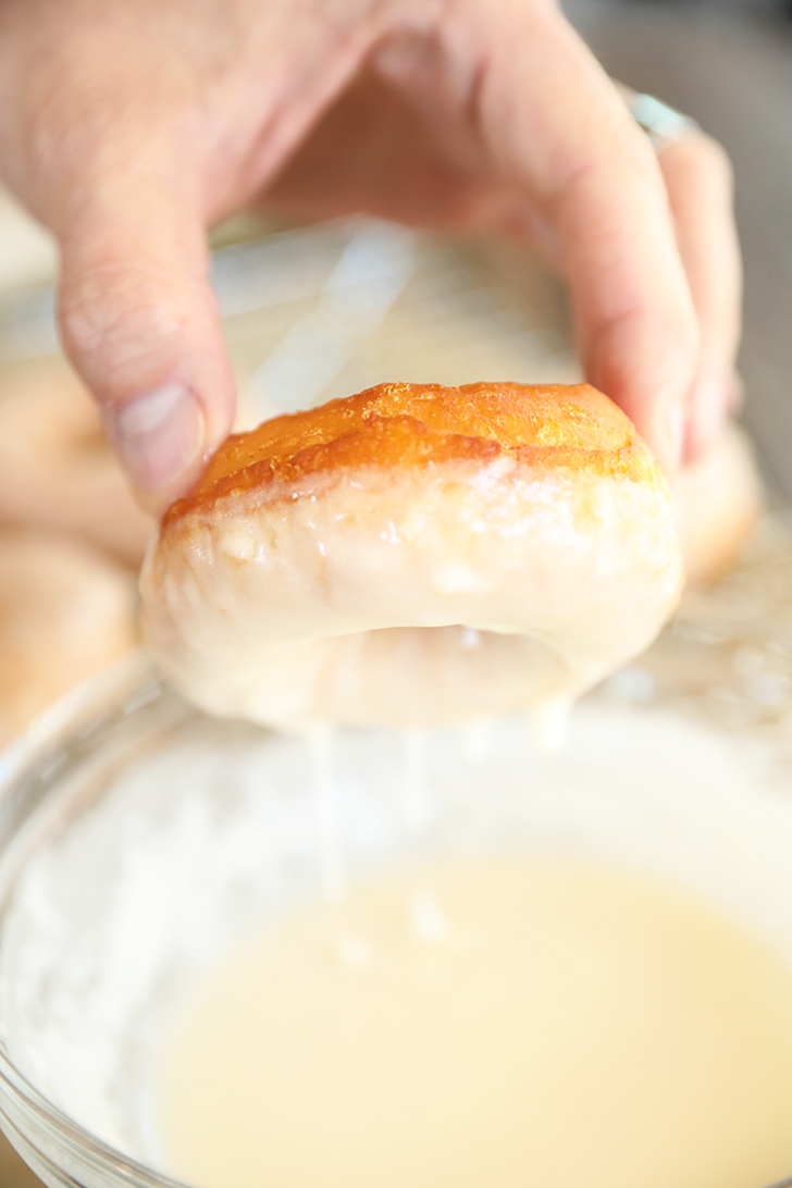 Dipping doughnut in glaze.