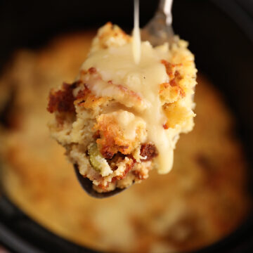 Gravy being poured over a scoop of Slow Cooker Cornbread Dressing