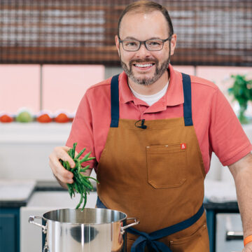 Stacey dropping green beans into pot.