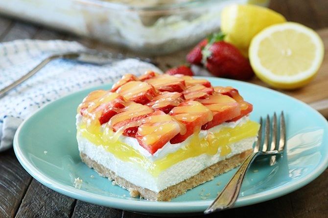 This recipe for Strawberry lemon Lush is sure to be your new favorite layered dessert! A Nilla Wafer crust topped with a layer of sweetened cream cheese, lemon pie filling, whipped topping, and it's all topped off with fresh strawberries drizzled in lemon curd!