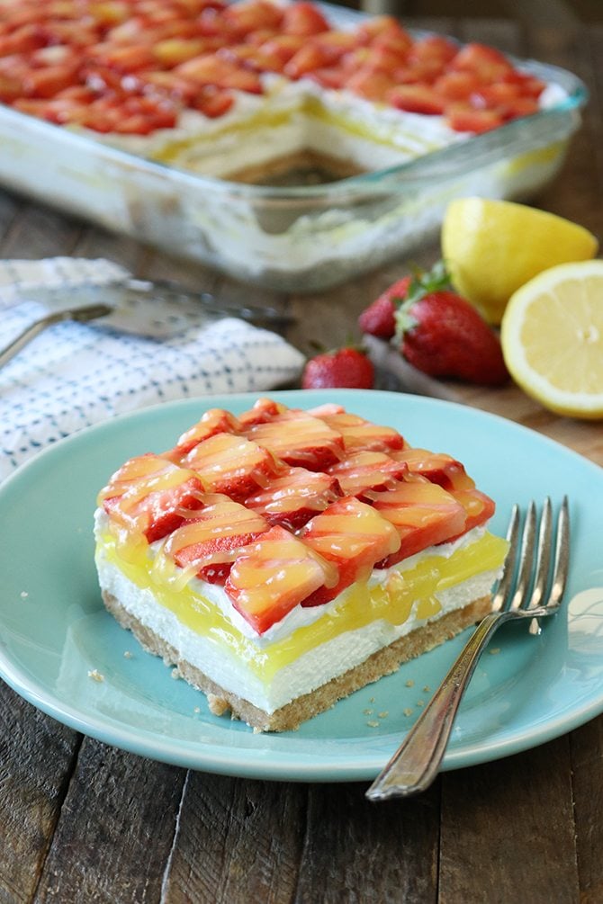 This recipe for Strawberry lemon Lush is sure to be your new favorite layered dessert! A Nilla Wafer crust topped with a layer of sweetened cream cheese, lemon pie filling, whipped topping, and it's all topped off with fresh strawberries drizzled in lemon curd!