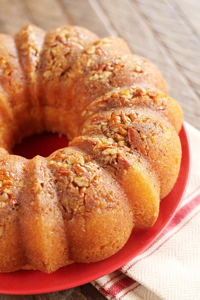 Whole rum cake topped with pecans. 