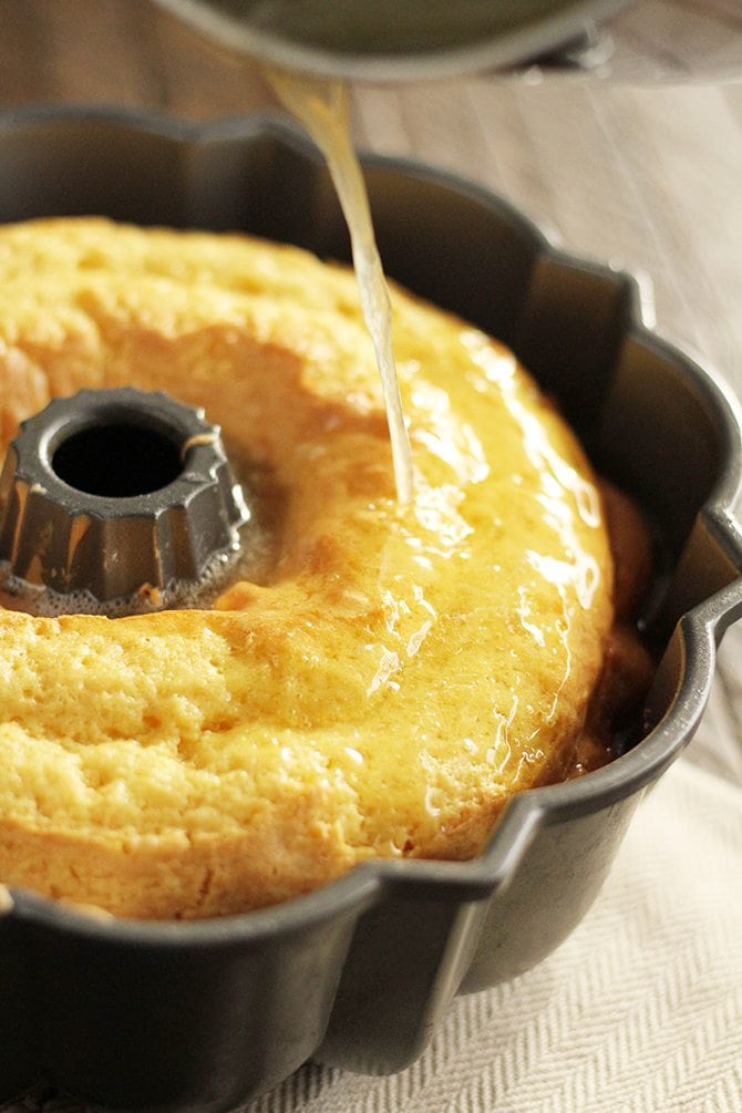 Rum glaze being poured over cake.