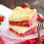 Slice of Strawberry Chess Bars with fresh strawberries in background