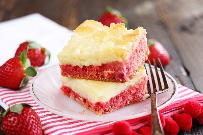 Slice of Strawberry Chess Bars with fresh strawberries in background