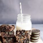 Stacked slices of Mint Oreo Brownies served with milk