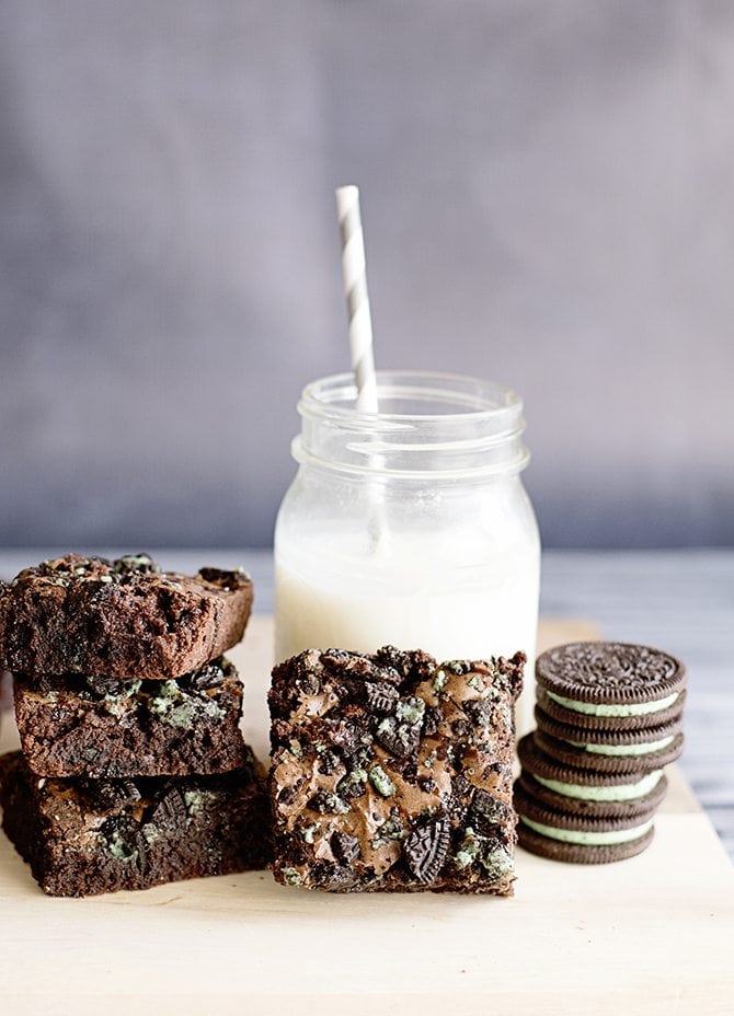 Stacked slices of Mint Oreo Brownies served with milk