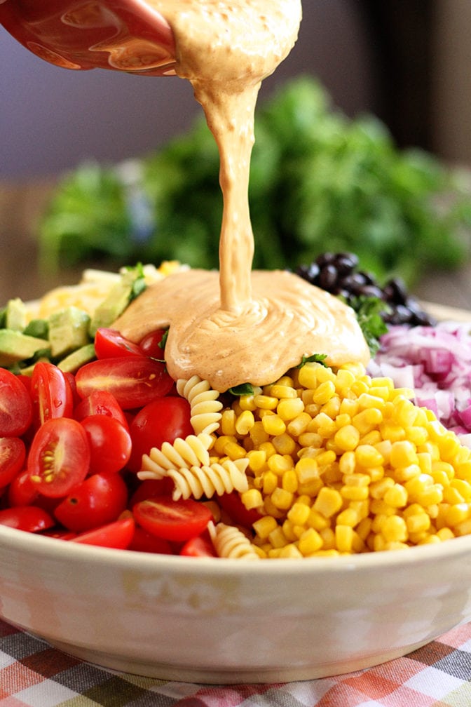 Taco Pasta Salad with dressing being poured on top