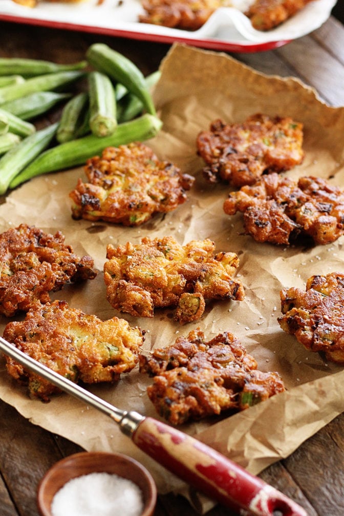 Okra and Green Tomato Fritters on serving platter with fresh okra in the background