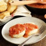 Biscuit covered with Southern Tomato Gravy with homemade biscuits in backbround