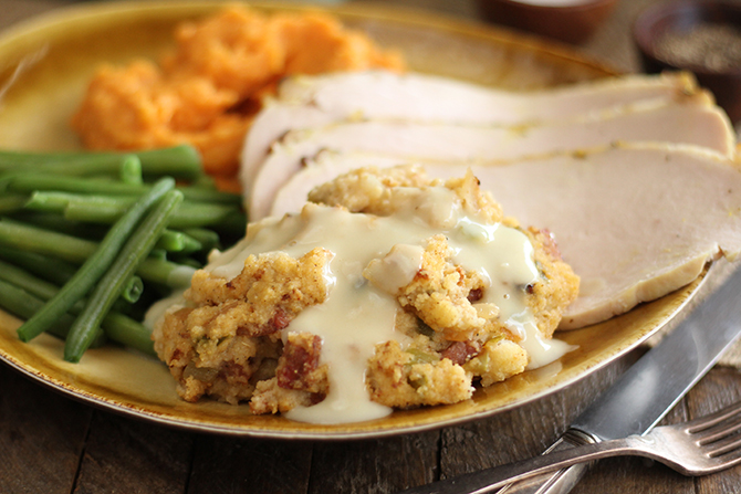 Close photo of Creole Cornbread Dressing served with sliced turkey and vegetables