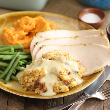 Creole Cornbread Dressing served with sliced turkey and vegetables