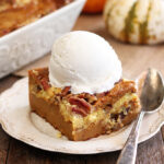 Pumpkin Spice Dump Cake on white serving dish with ice cream on top