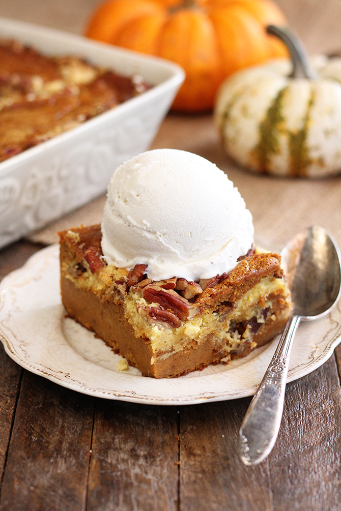 Pumpkin Spice Dump Cake on white serving dish with ice cream on top.