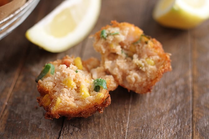 Shrimp and Corn Fritters cut in half with lemon on side