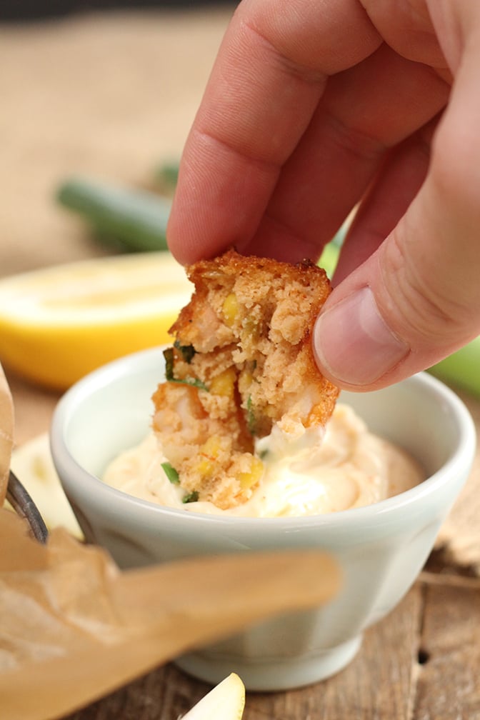 Shrimp and Corn Fritter being dipped in sauce