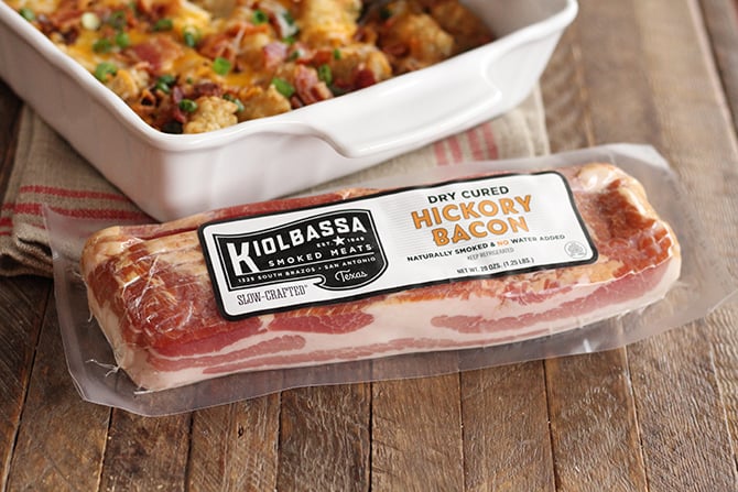 Bacon and Eggs Tater Tot Casserole in baking dish with package  of bacon in the foreground