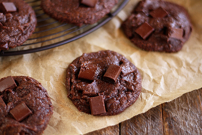 Fudgy Brownie Cookies on brown paper beside platter of cookies