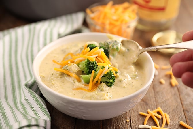 Broccoli an Cheese Soup lifting spoonful out of bowl