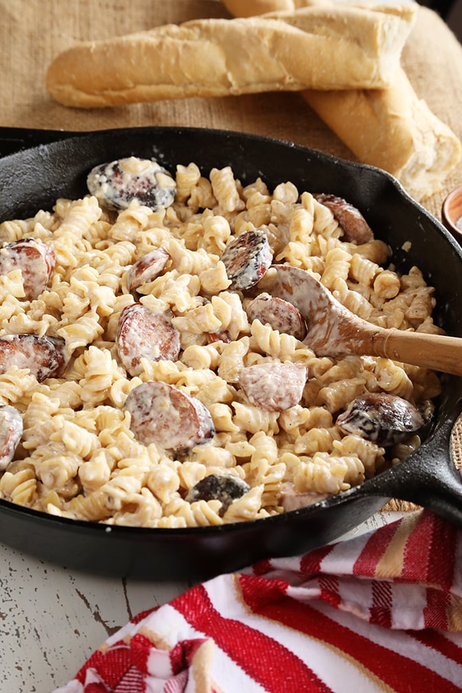 Weeknight Sausage Alfredo in cast iron skillet and break in background