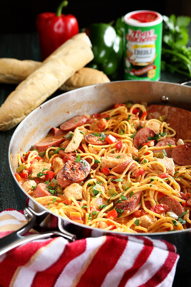 Creamy One Pot Jambalaya Pasta in pan with seasoning and bread in back ground