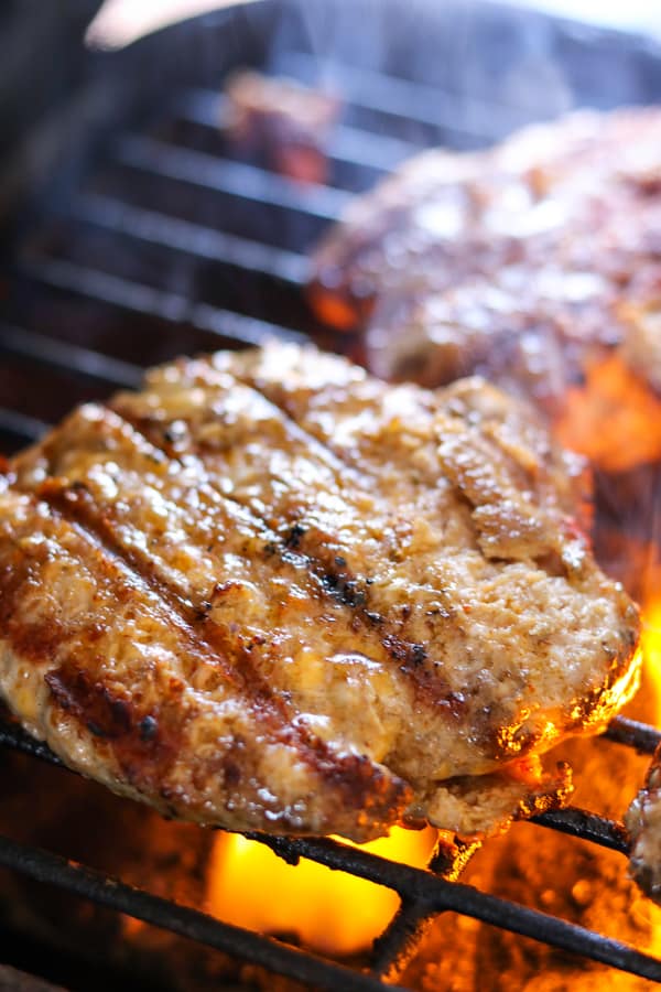Cheesy spiced pork burgers on being cooked on grill