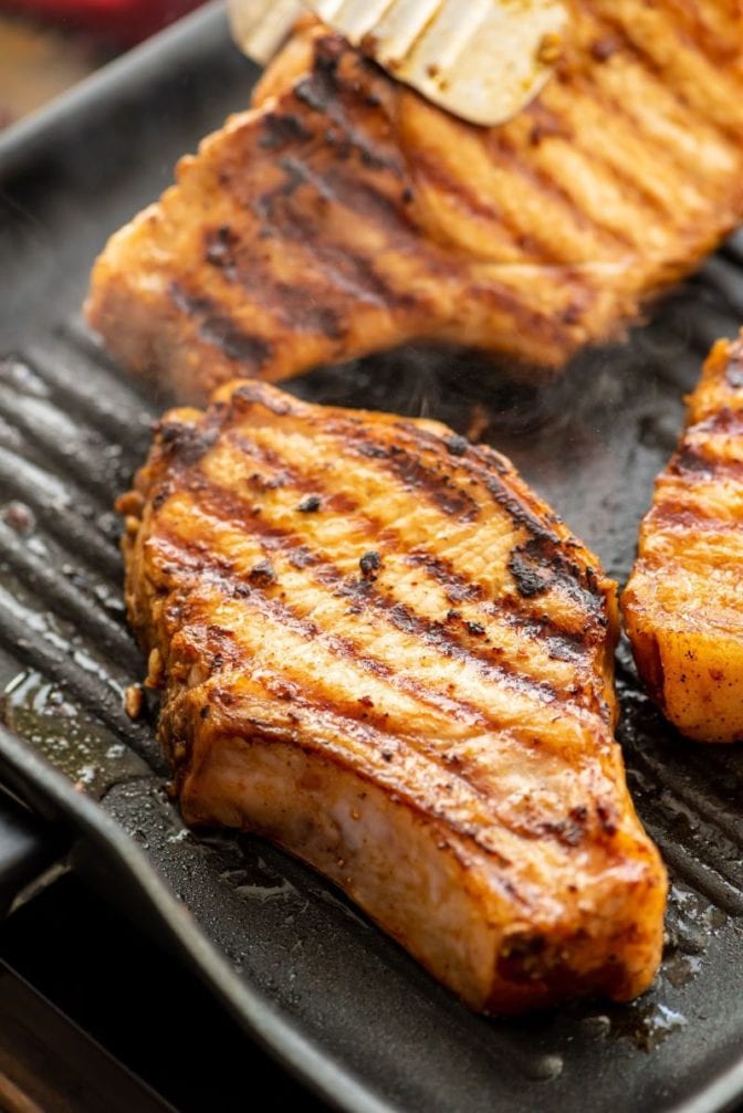Pork chops being cooked on grill