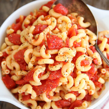 Macaroni and tomatoes served in white bowl