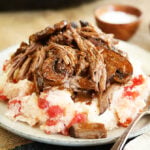Slow cooker pot roast served over tomato grits closer photo