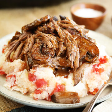 Slow cooker pot roast served over tomato grits closer photo