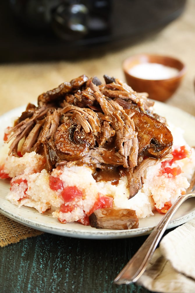 Slow cooker pot roast served over tomato grits closer photo
