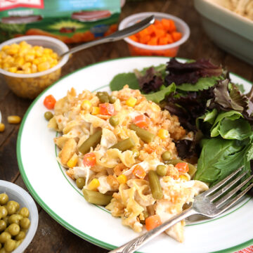 Family Favorite Chicken Noodle Casserole served on plate with canned vegetables in background