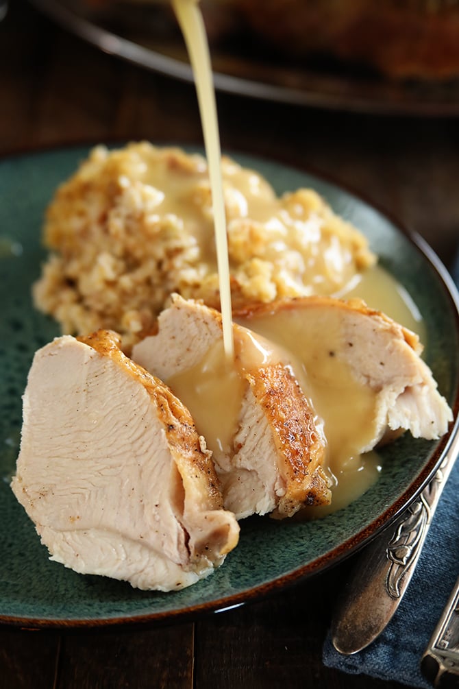 Slices of Turkey and Dressing with Turkey Gravy being poured over