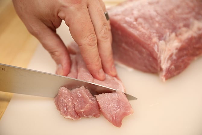Cutting raw pork into pieces