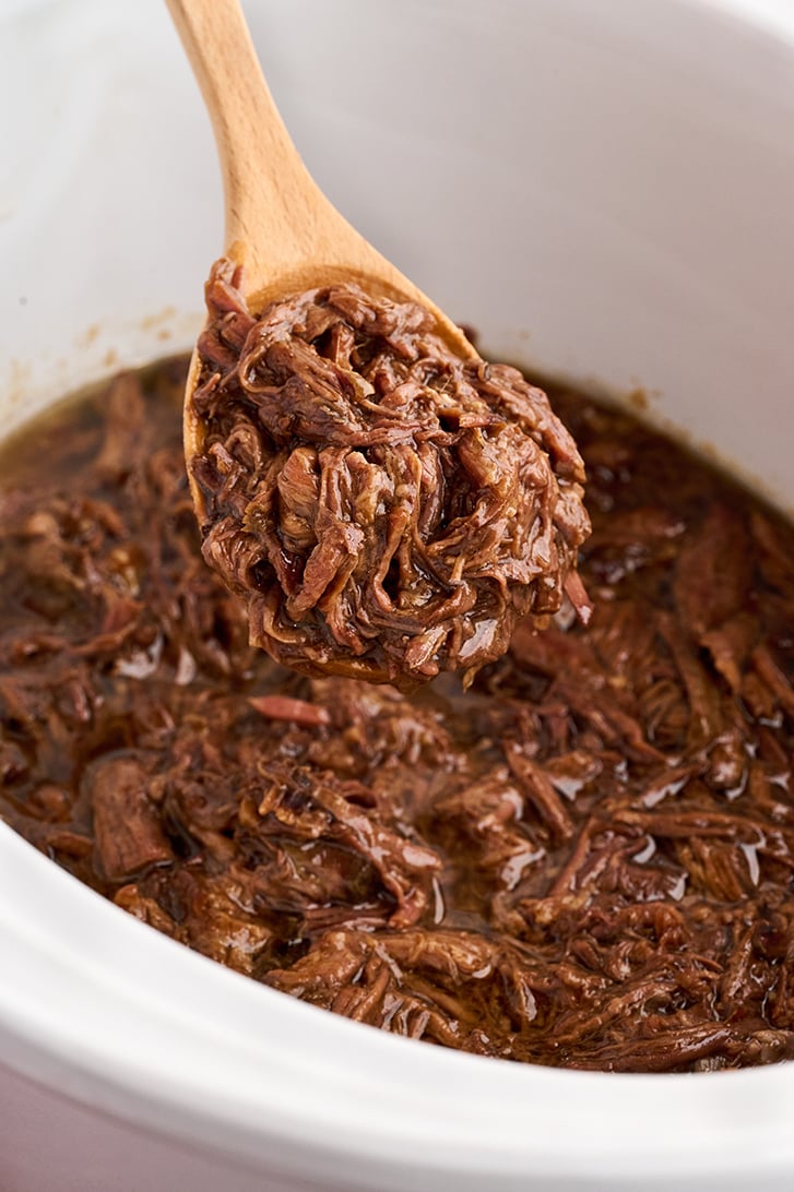 Scoop of shredded roast beef on a spoon.