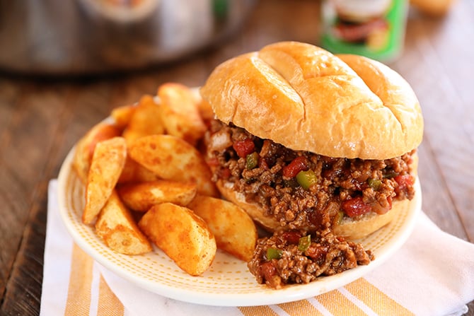 Creole Sloppy Joes on a white plate with potato wedges