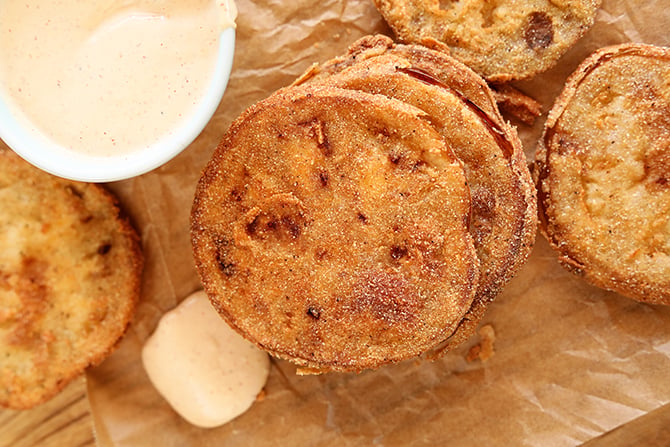 Top view of fried green tomatoes on borwn paper with remoulade sauce