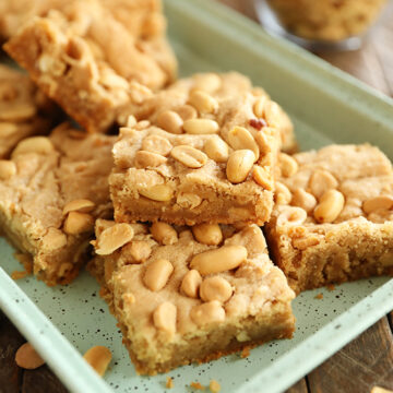 Chewy peanut Butter Cookie bars stacked on green tray
