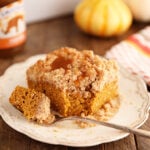 Bite taken out of piece of Carmel Pumpkin Crumb Cake