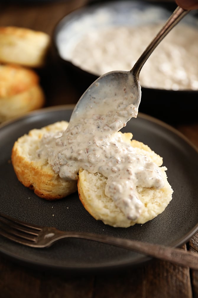 Sausage Gravy being poured over a biscuit