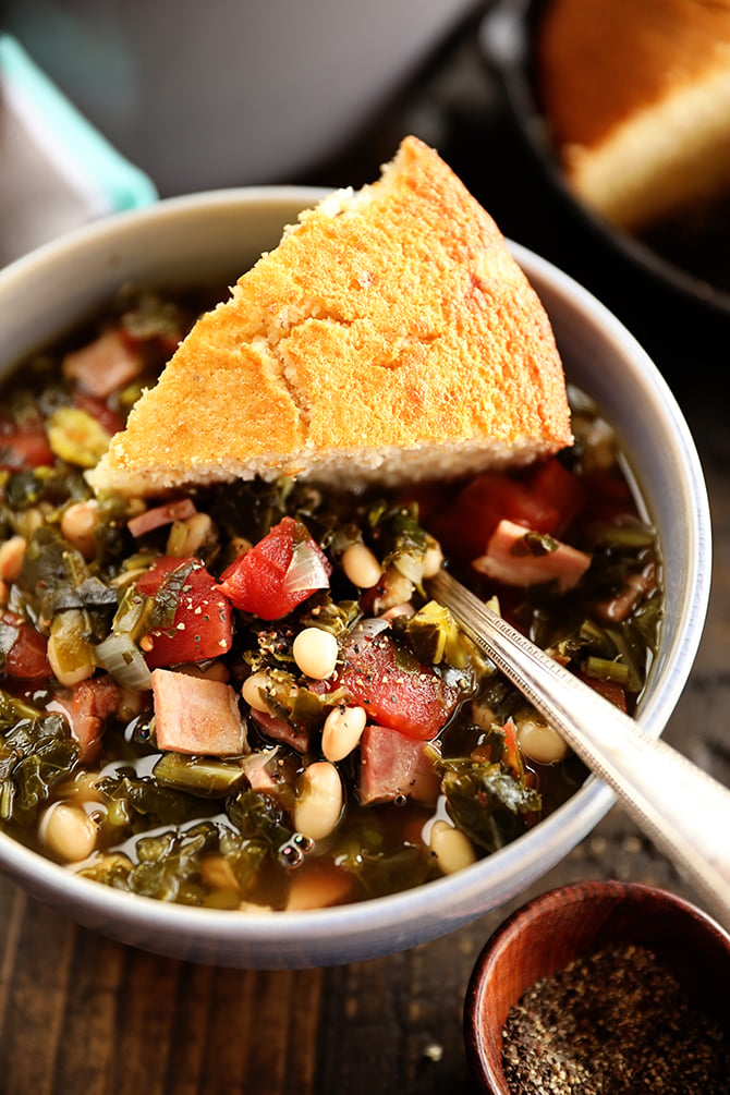 Bowl of Collard Green Soup with Ham and Beans with cornbread