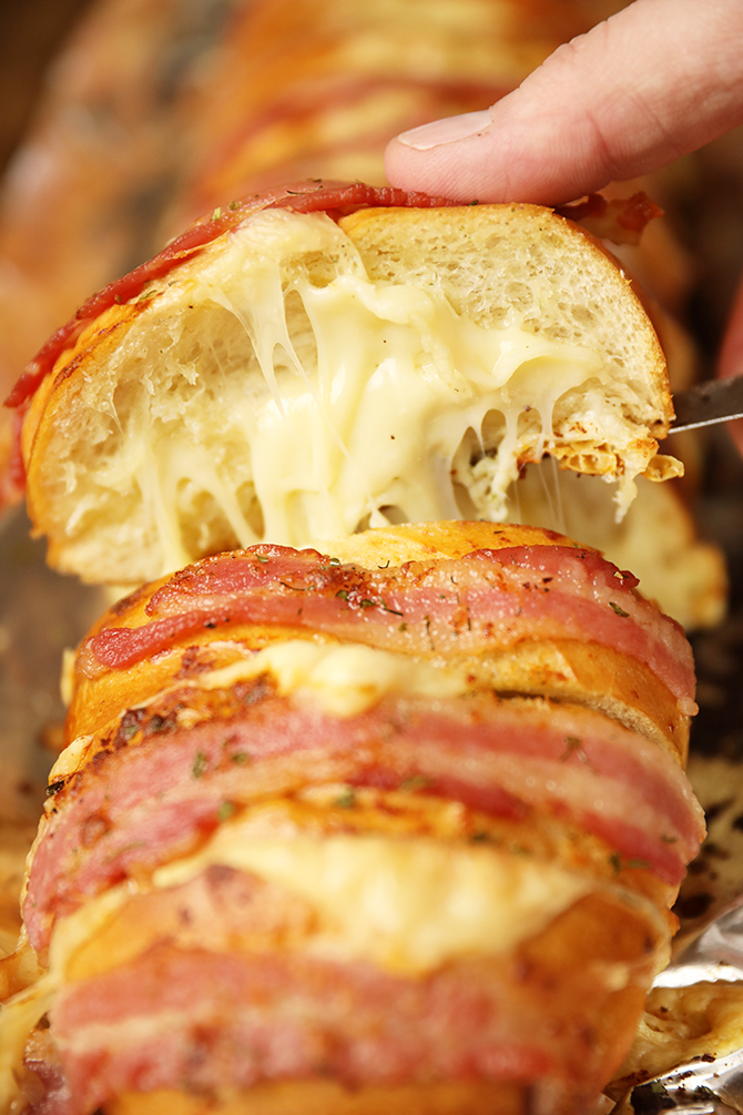 Slice of Cheesy Swiss Bacon Ranch Bread with cheese pull
