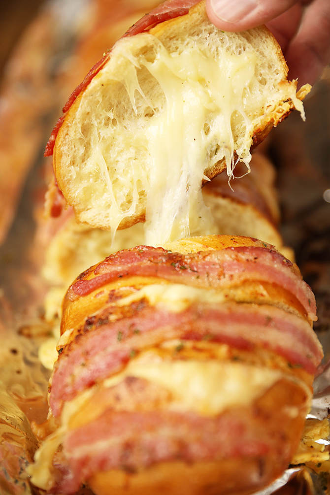 Slice of Cheesy Swiss Bacon Ranch Bread with cheese pull