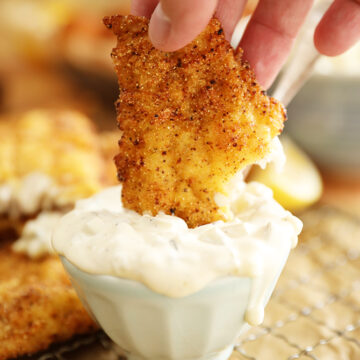 Piece of Fish being dipped into Dill Pickle Tartar Sauce